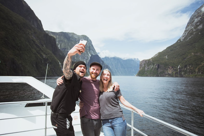 Group taking a selfie on the deck of a boat in Milford Sound in New Zealand