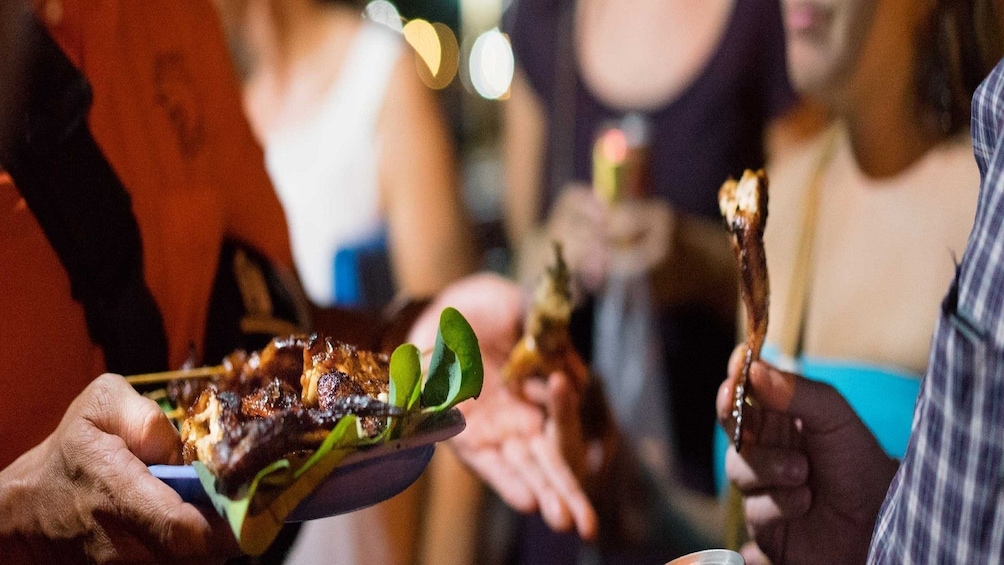 Group eating barbecue skewers in Phnom Penh