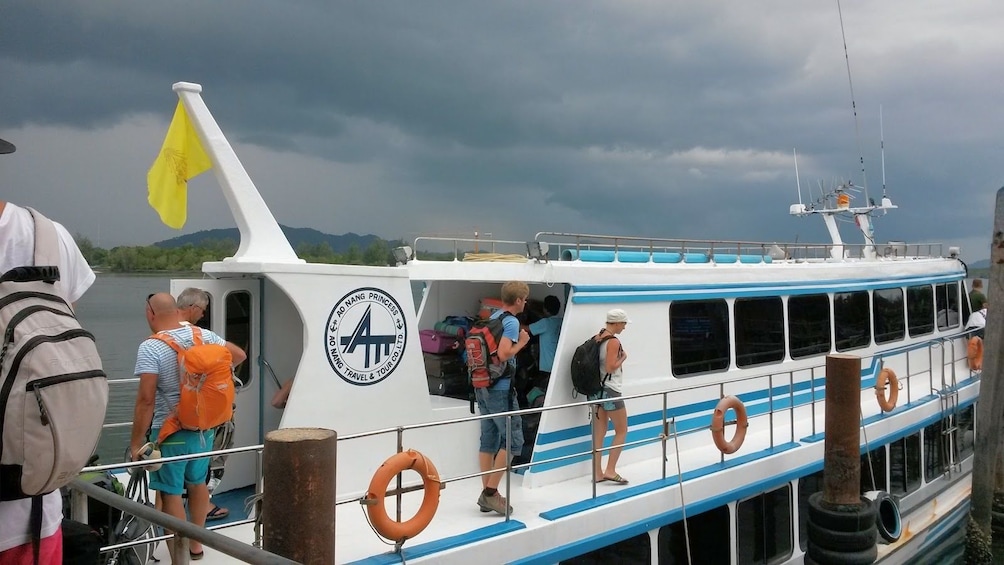 Passengers board ferry to Koh Lanta Yai, Thailand on a cloudy day