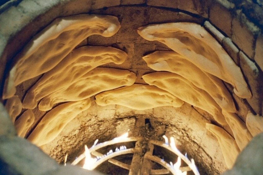 Show item 2 of 4. Traditional Georgian bread in an oven