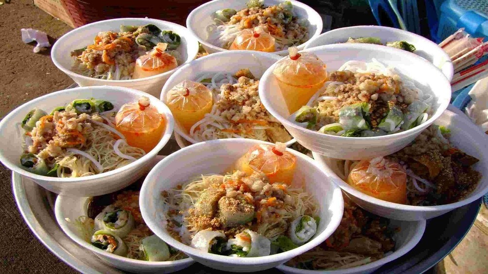 Many noodle dishes stacked in white bowls 