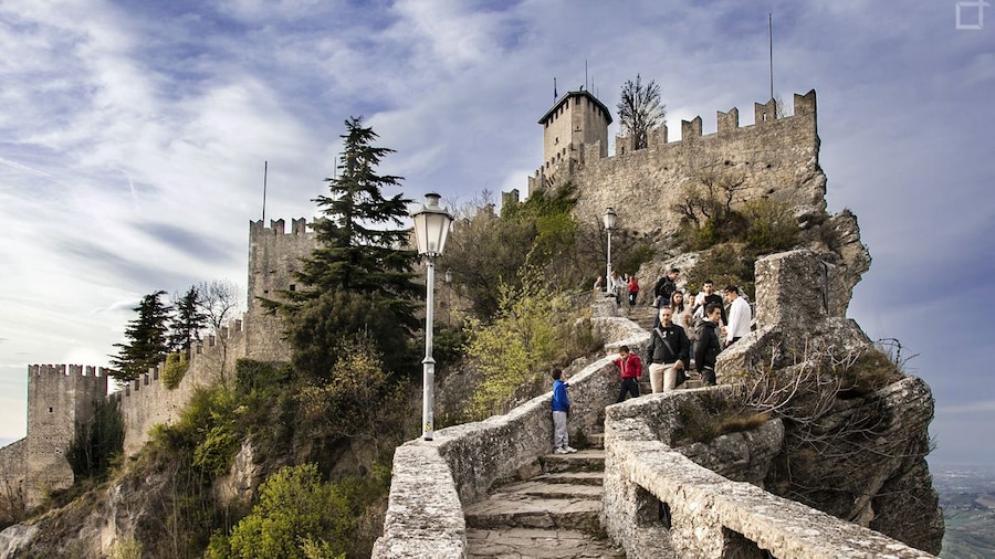 People walking up stone stairs to the top of mountain in San Marino