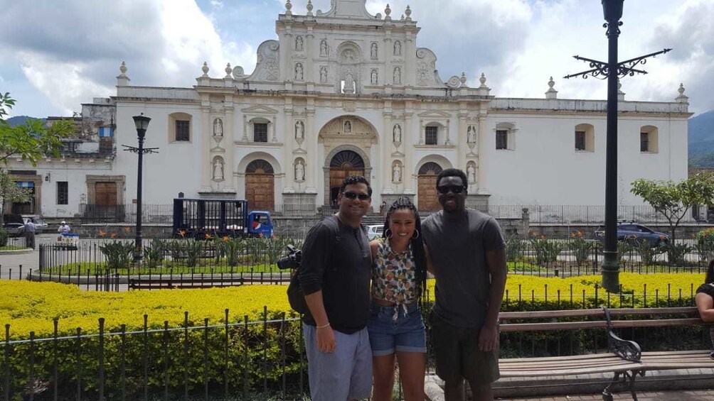 Tourists pose in front of Antigua Guatemala Cathedral