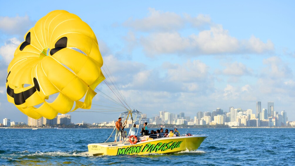 Parasailing boat dragging a happy face parachute