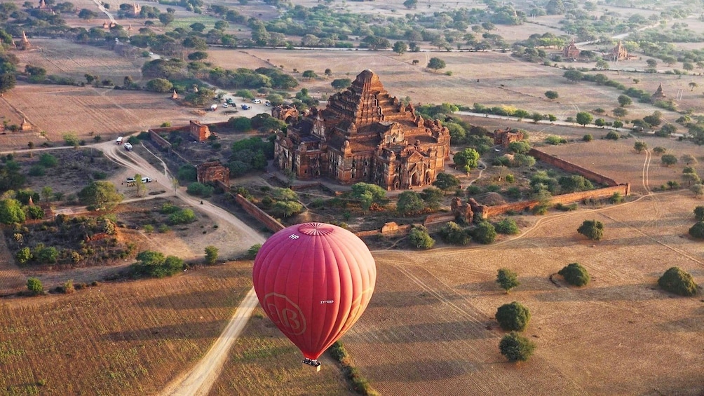 Red hot air balloon with Dhammayangyi Temple in the background