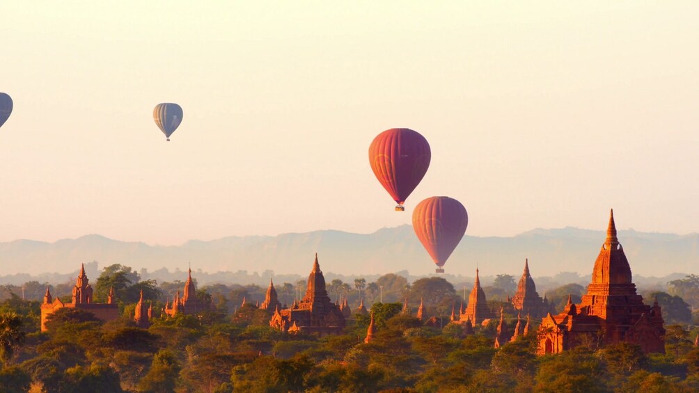 Hot air balloons float over temples of Old Bagan on foggy day