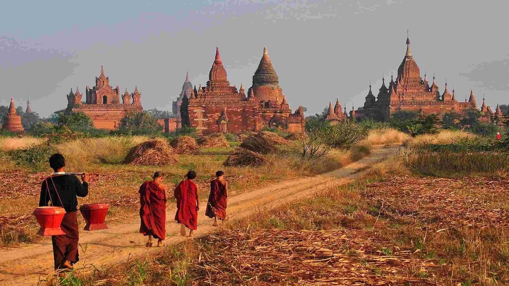 Young monks walk towards temples of Old Bagan in Myanmar