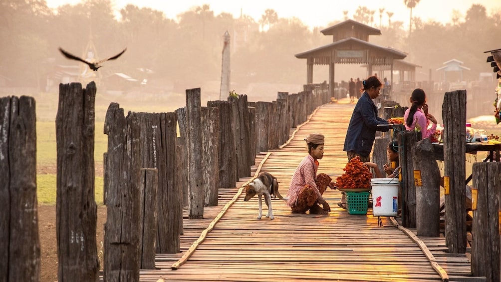 People sell food on long dock on a foggy day in Bagan, Myanmar