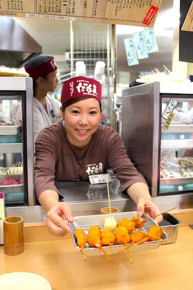 Person serving fried food in an Osaka restaurant