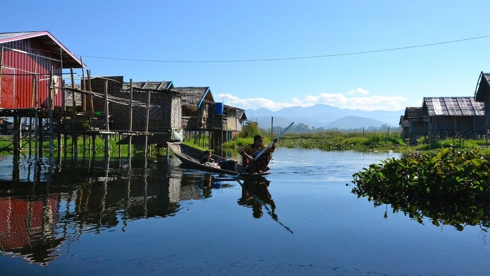 Boat passing stilt houses on a lake in Myanmar