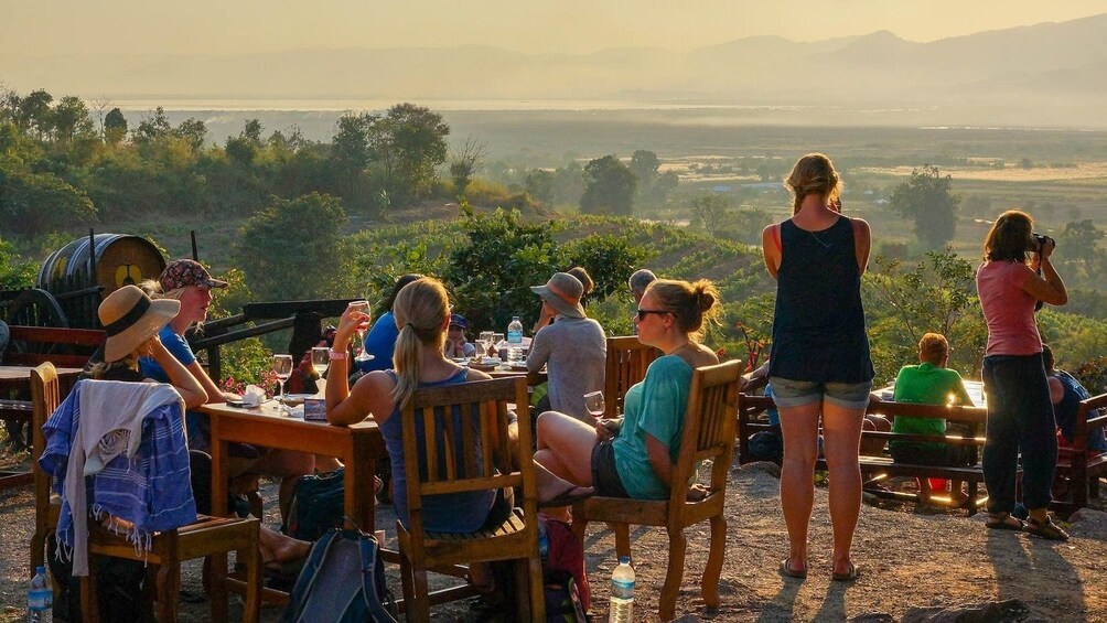 Group enjoying wine on Red Mountain in Nyaungshwe, Myanmar 