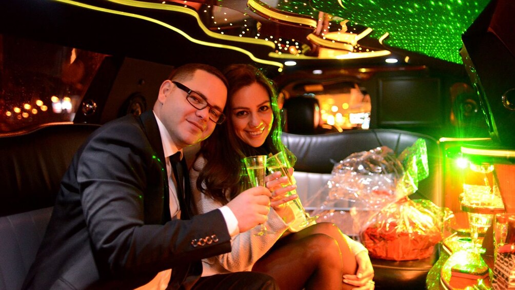 Couple toasting with champagne in a limo in Paris