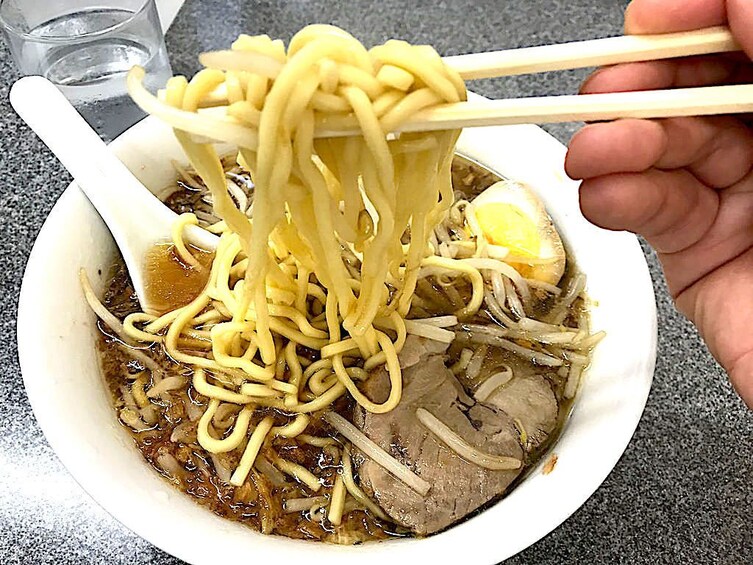 Guest eating a bowl of ramen at a local Ramen shop in Shibuya