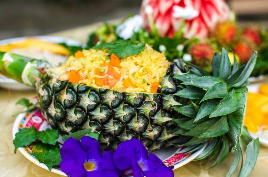 Fried rice dish in halved pineapple with floral garnish
