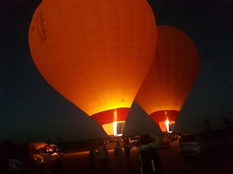 Two adjacent hot air balloons prepare for takeoff