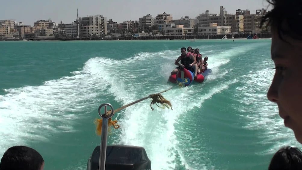 Show item 4 of 9. Group on a banana boat in the water on Giftun Island