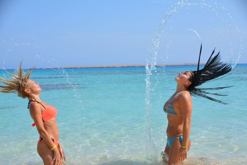 Show item 3 of 9. Women whipping their hair back and forth on the beach on Giftun Island
