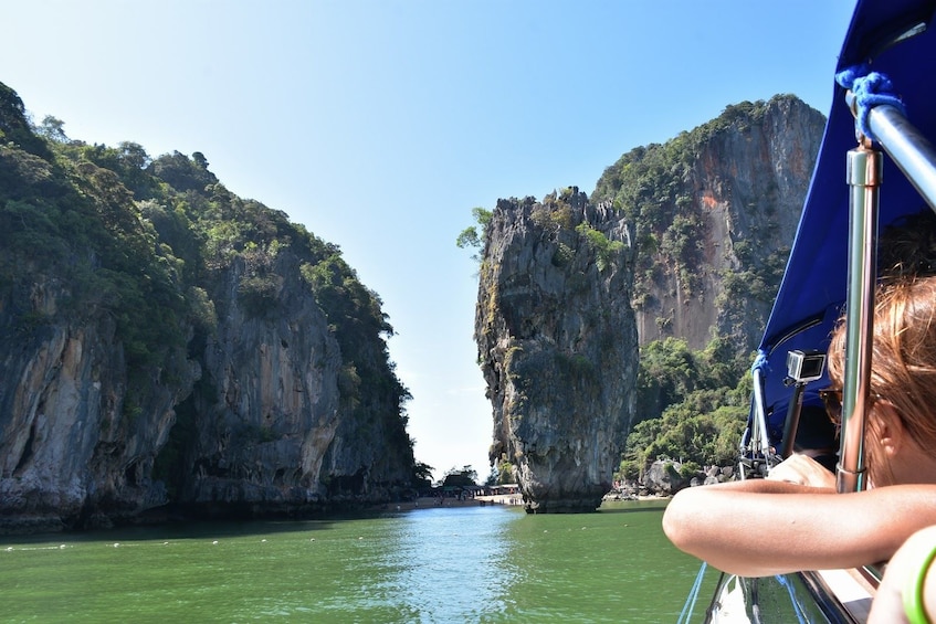 Boating passengers near rock formations on an island in Thailand