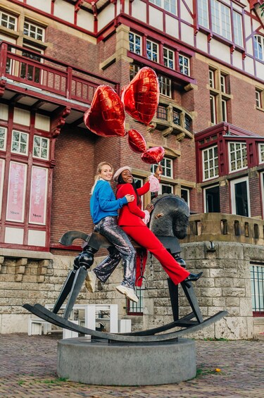 Two friend's pose on large horse sculpture outside of Moco Museum