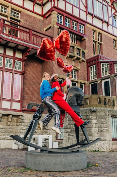 Two friend's pose on large horse sculpture outside of Moco Museum