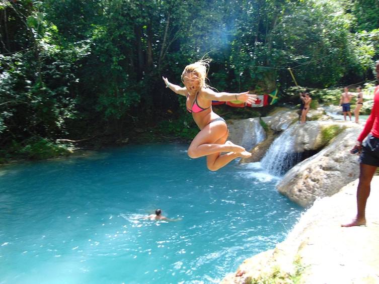 Woman jumping into the water in Jamaica