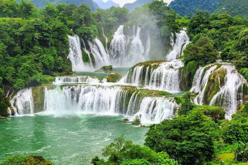 Gushing Ban Gioc Waterfall with lush surroundings