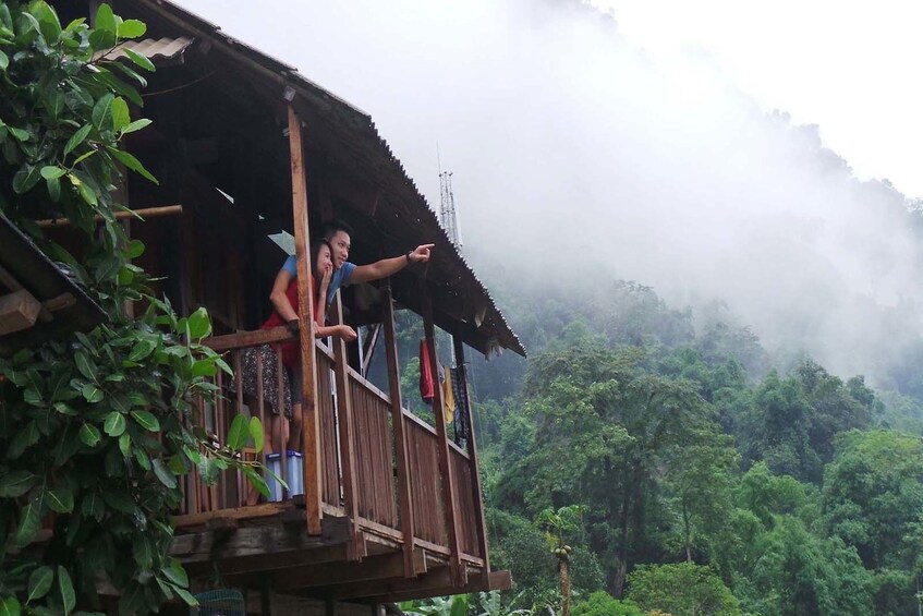 Couple look out from balcony over Ba Be Lake in Vietnam