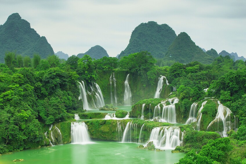 Panoramic view of Ban Gioc Waterfall with mountains behind it