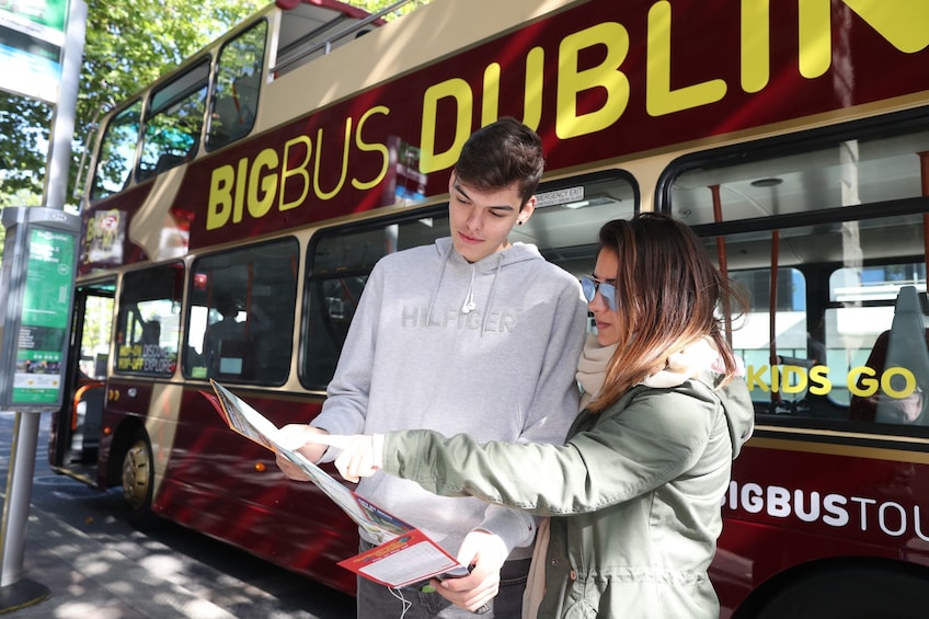 Two people looking at a map, standing just off of the Dublin Hop-On Hop-Off Bus 