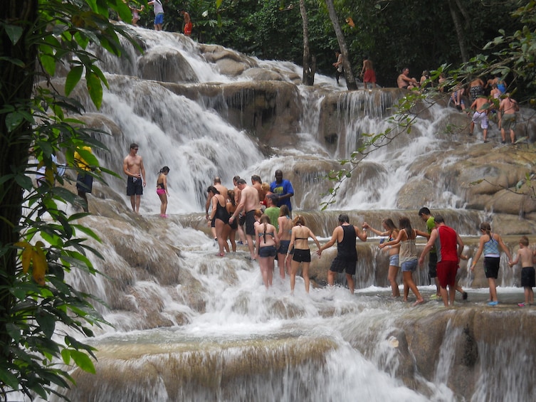 People climbing a waterfall in Jamaica