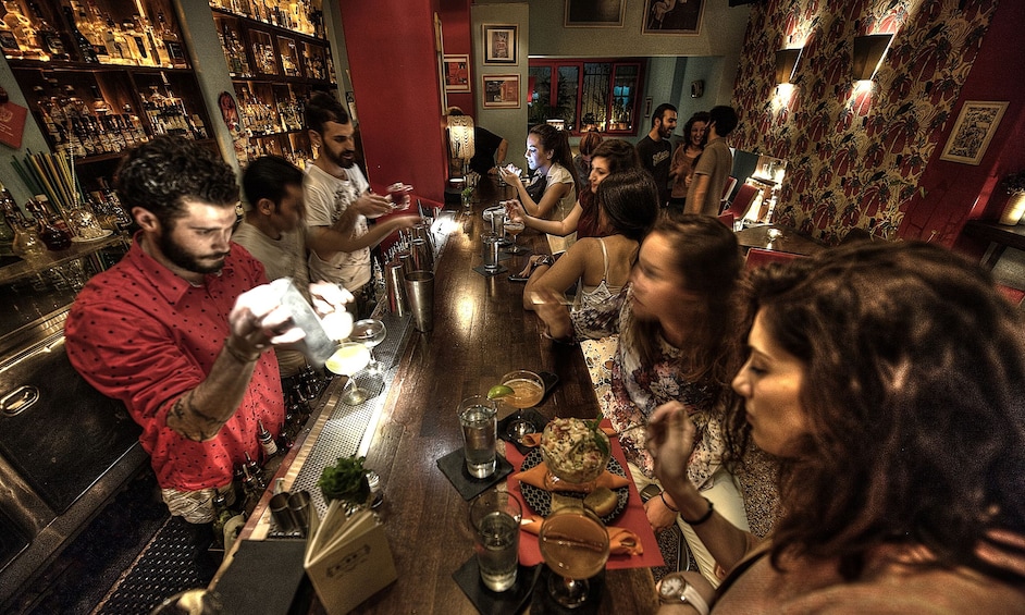People enjoy appetizers and drinks at bar in Athens, Greece