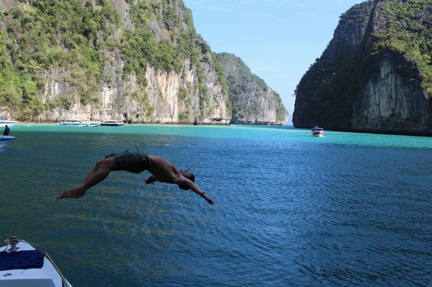 Man jumping into the water from a boat in Phi Phi Island