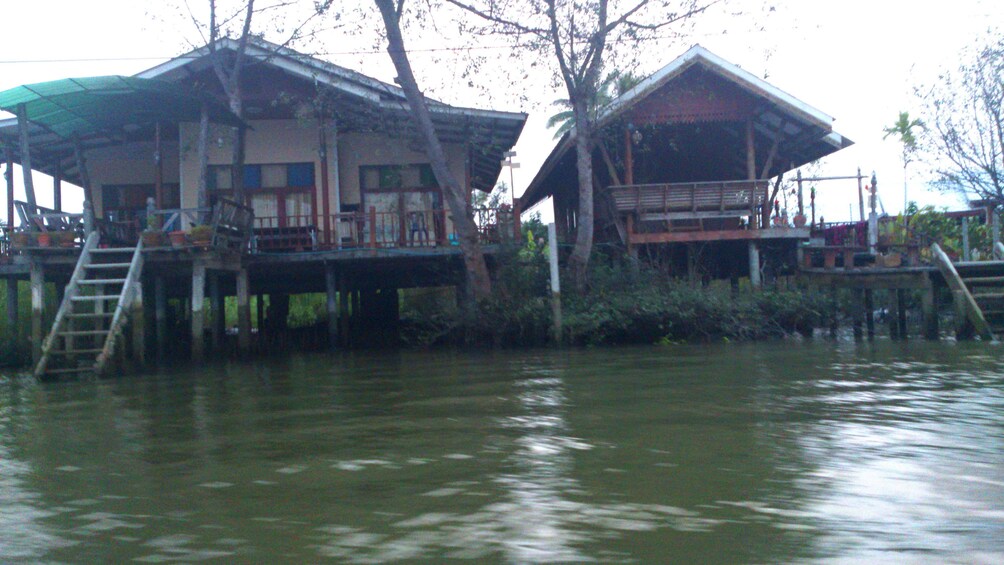 Two houses on the banks of a river in Maeklong
