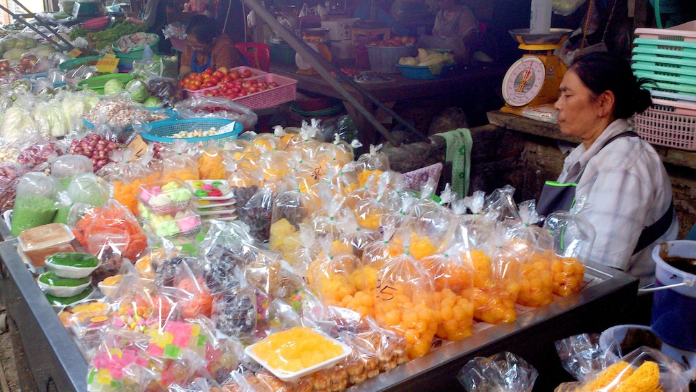 Show item 5 of 11. Woman sells candy goods at the Maeklong Risky Market