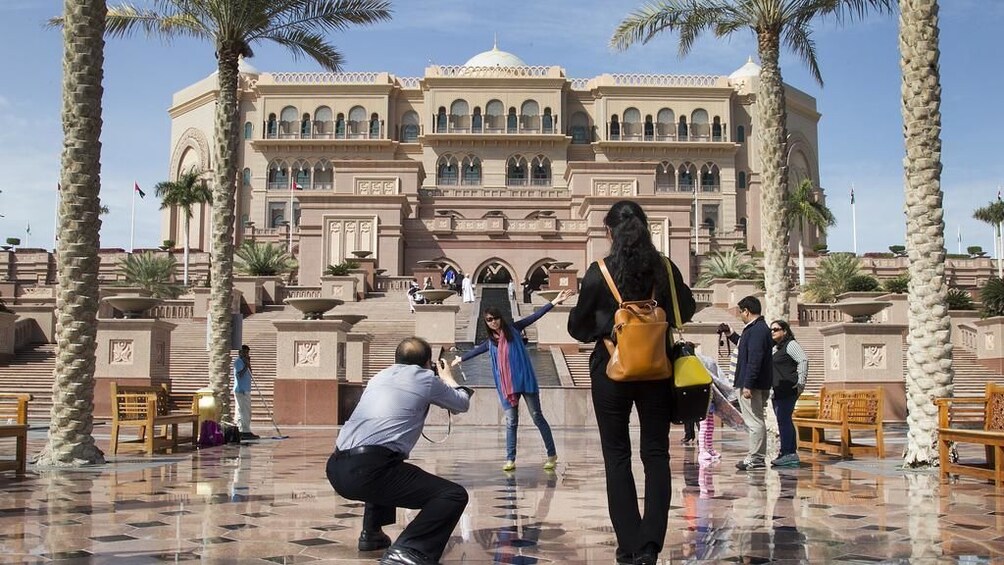 Woman getting her photo taken in front of Emirates Palace in Abu Dhabi
