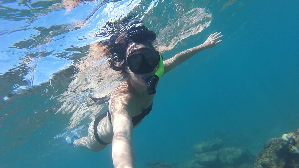 Woman snorkeling off the boat in Banana Beach