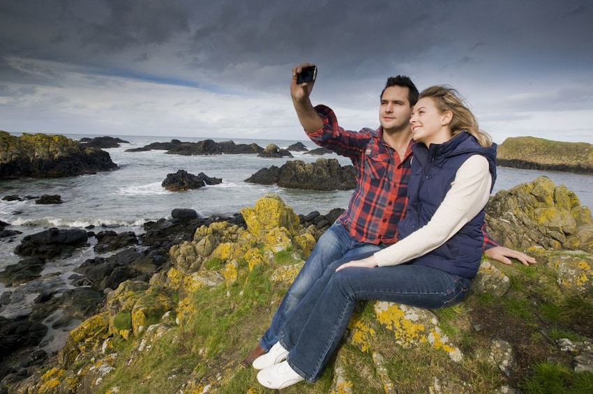 Couple taking a selfie at Giants Causeway in Ireland