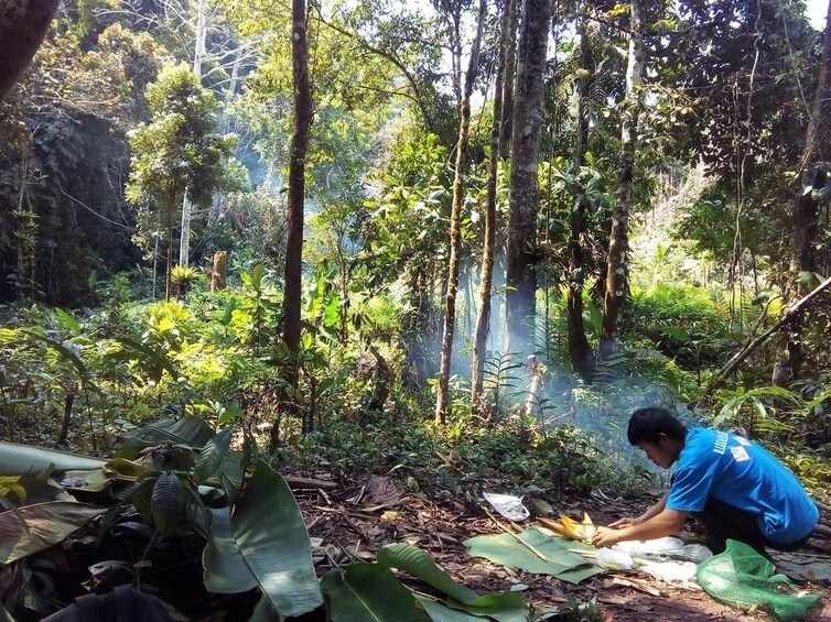 Man makes fire in jungle of Nam Ha National Park