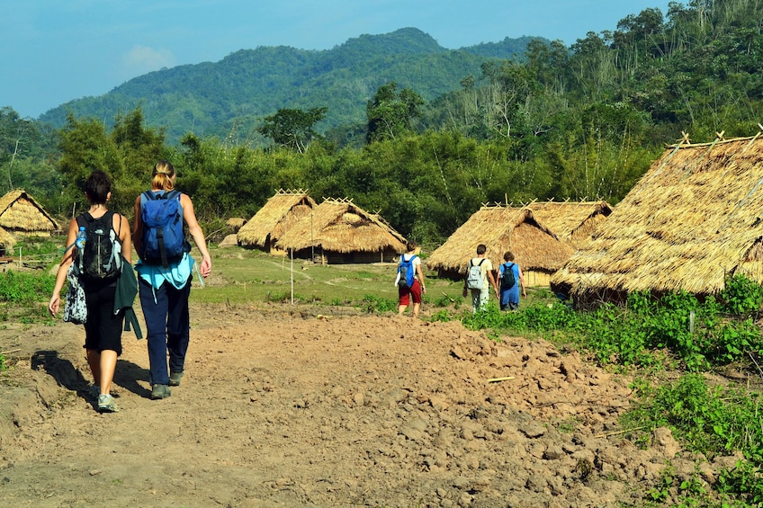Tourists walk through Akha Village in Laos