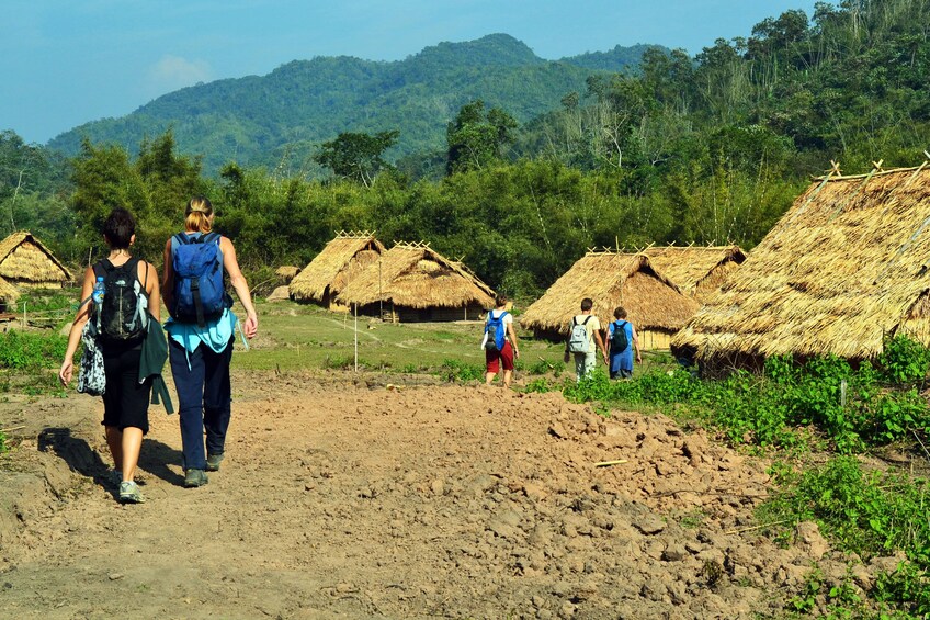 Tourist group walking through a village in Luang Namtha
