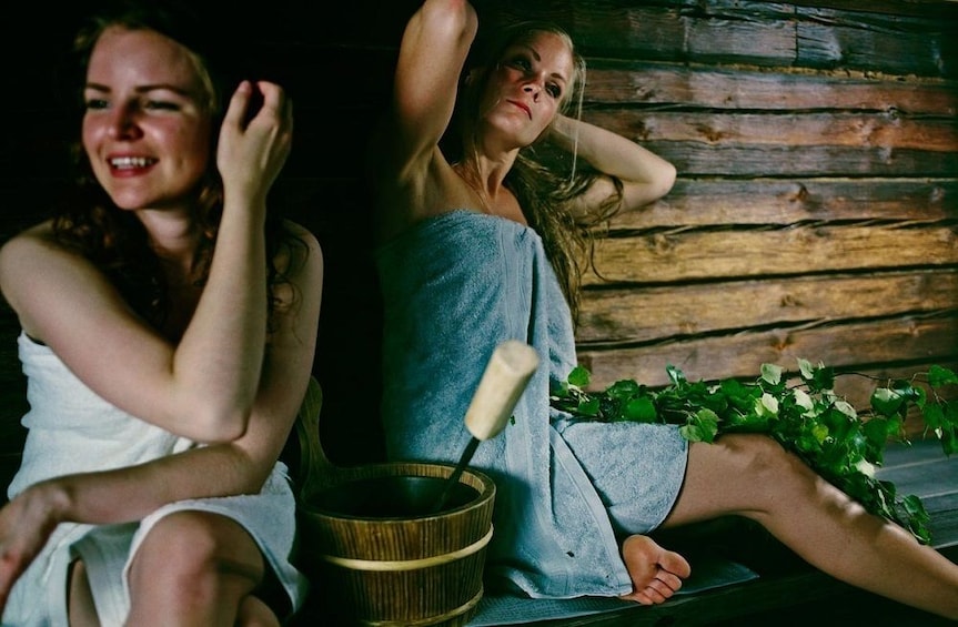 Women enjoying a relaxing Lakeside Finnish traditional sauna experience in Rovaniemi