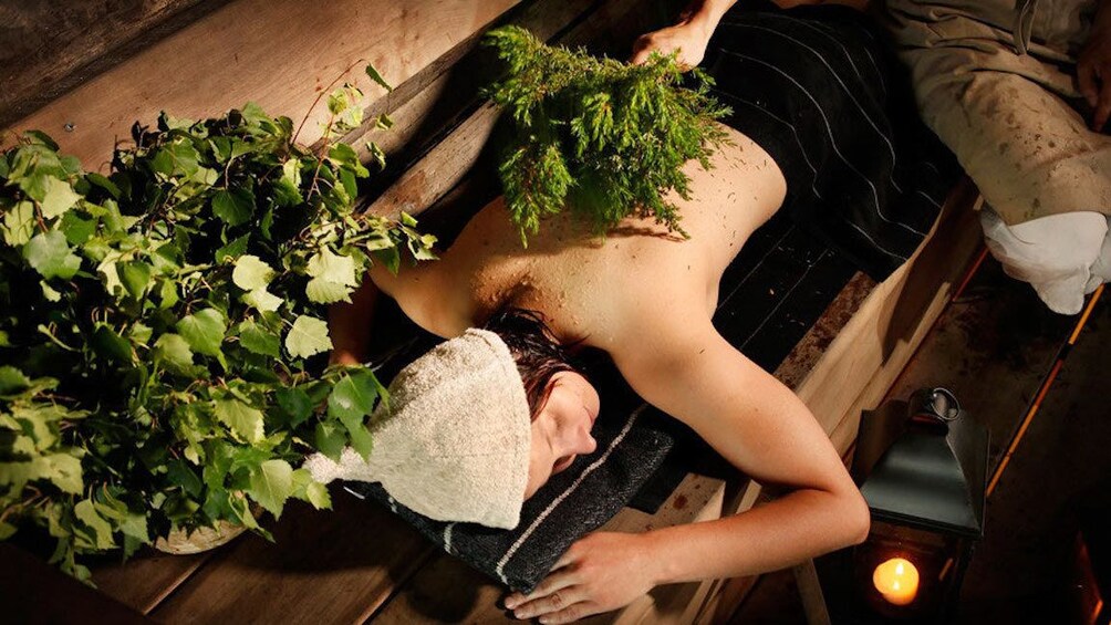 Woman relaxing on the Lakeside Finnish traditional sauna experience in Rovaniemi