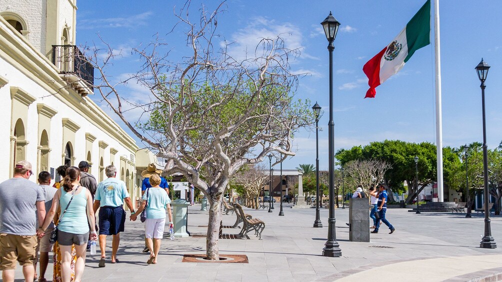 Tour group walking along the sidewalk in Los Cabos on a sunny day 