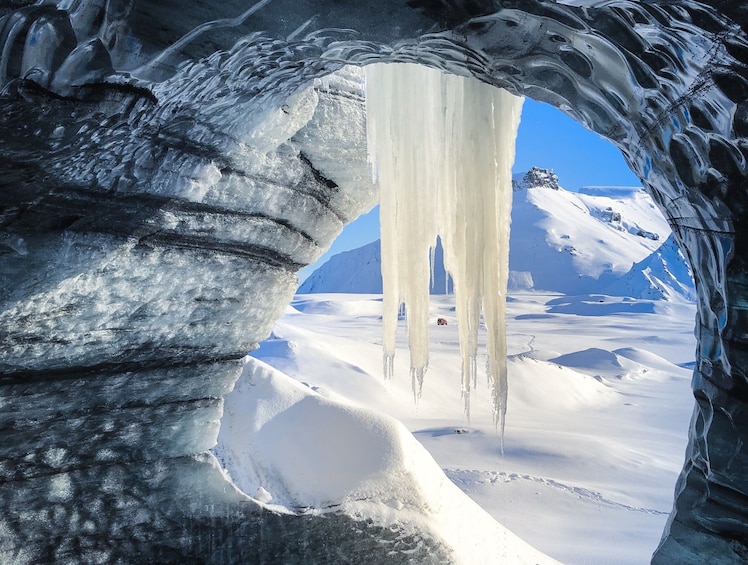 View out of mouth of Katla Ice Cave with large icicles hanging down