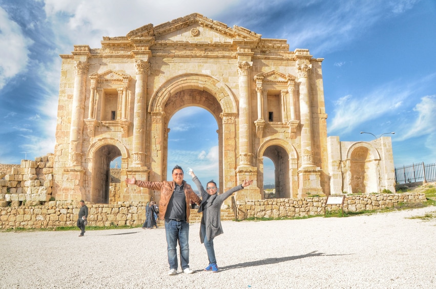 Couple standing in front of the Arch of Hadrian in Jerash, Jordan
Source: