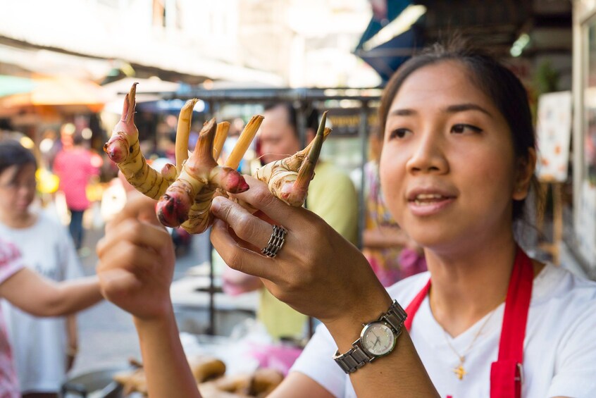 Woman shopping for produce at a local market in Bangkok