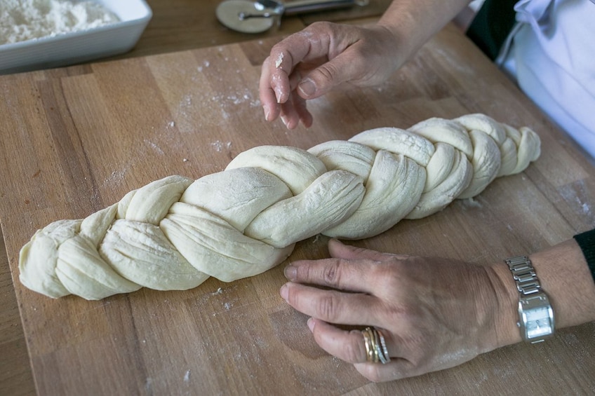 Woman braiding bread dough in Asti