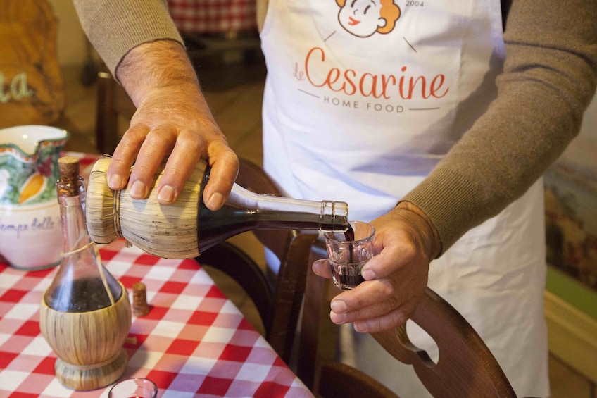 Man pouring a shot of alcohol in a cooking class in Lake Maggiore