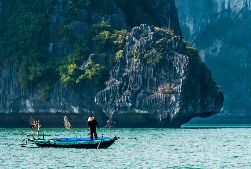 Man stands on fishing boat in Halong Bay