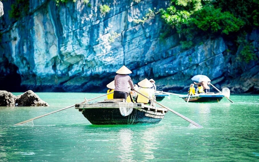 Small boats being rowed in Halong Bay, Vietnam